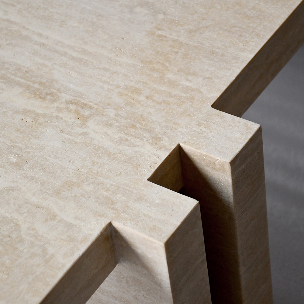 Sculptural travertine coffee table with geometric interlocking base - wabi-sabi design